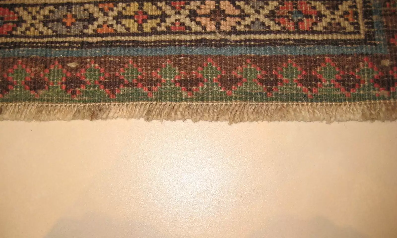 Exemple de réparation de tapis réussie (arrêt de frange) dans le cadre de nos services de nettoyage et réparation de tapis.