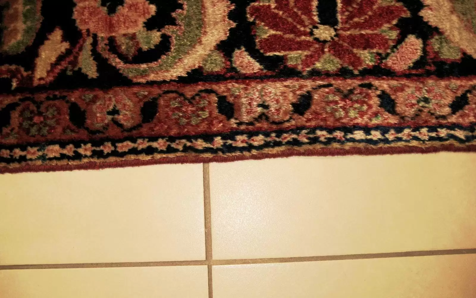 Tapis d'Orient après réparation de la lisière, montrant la restauration soignée