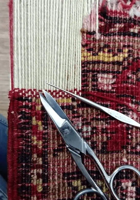 Restauration d'un trou en cours sur un tapis d'Anatolie