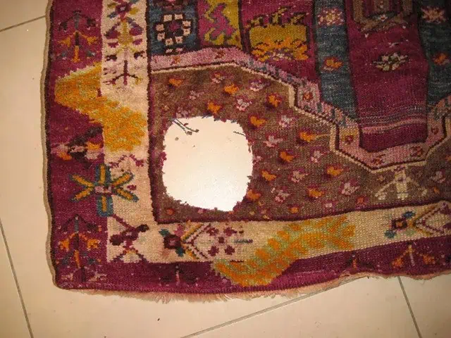 Tapis oriental endommagé avec un trou