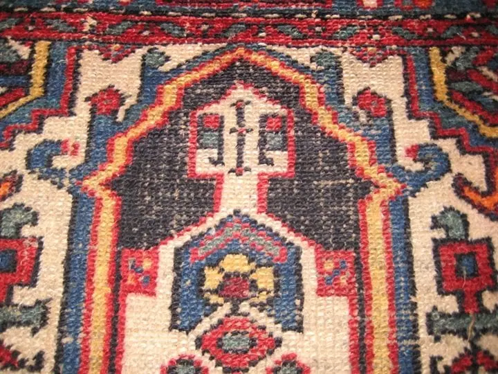 Photo gros plan d'une zone très usée d'un tapis persan de Hamedan (Iran), circa 1920, montrant l'état avant la restauration des couleurs.